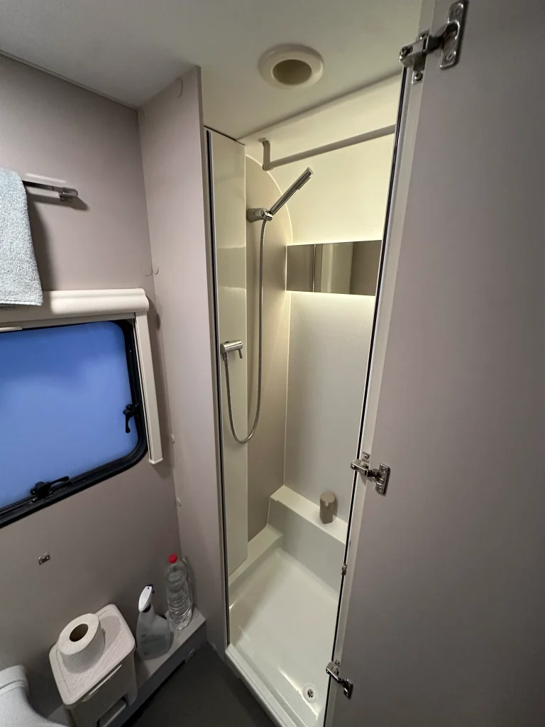 תא מקלחת בקרוואן Adria 573PT – מים חמים ונוחות מלאה גם בשטח