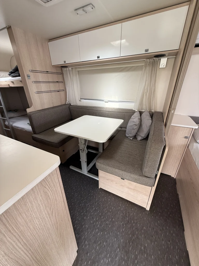 סלון חצי עגול בקרוואן Adria 563 – כולל חלונות, שולחן ותאורה חמה